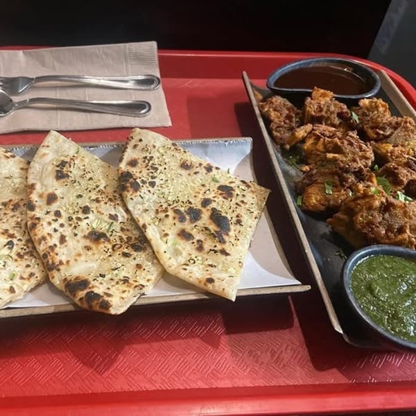 Indian flatbread, fried chicken, and two dipping sauces on a red tray at Hamara Restaurant.